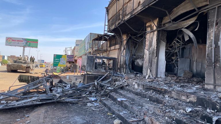 A burnt-out pharmacy as the Halfaya roundabout in Omdurman as Sudanese armed forces soldiers keep watch