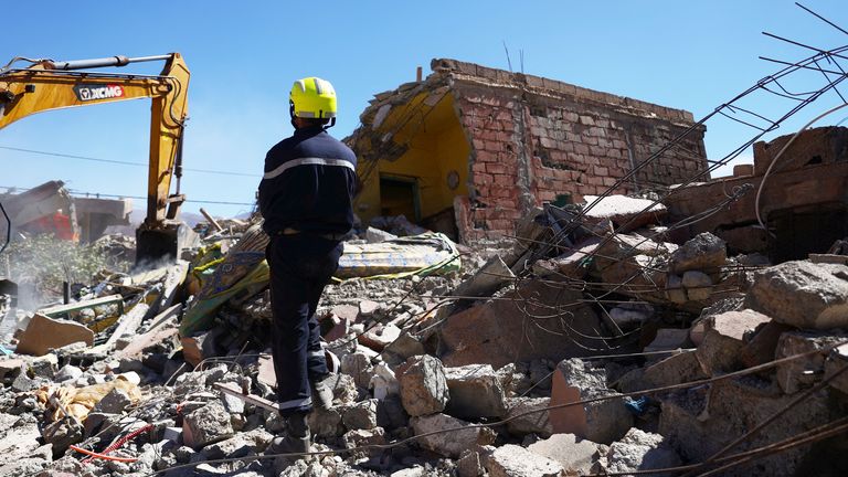 A worker stands among rubble in the aftermath of a deadly earthquake in Talat N'yaaqoub, Morocco 