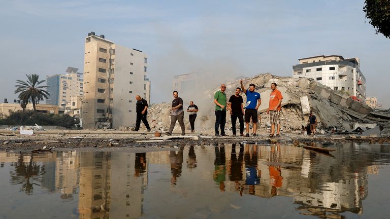 Palestinians inspect the ruins of Watan Tower, which was destroyed in Israeli strikes, in Gaza City October 8, 2023. REUTERS/Mohammed Salem TPX IMAGES OF THE DAY