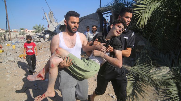 Palestinians evacuate a wounded youth after an Israeli airstrike in Rafah, Gaza Strip, Friday, Oct. 13, 2023. (AP Photo/Hatem Ali)